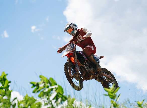Motocross che esegue salto