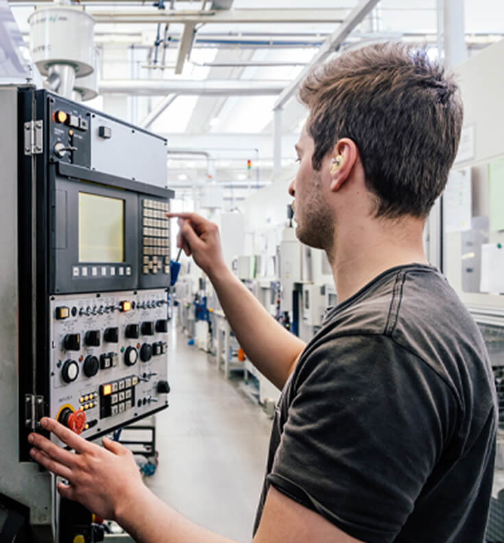 Operatore al lavoro su una macchina CNC.