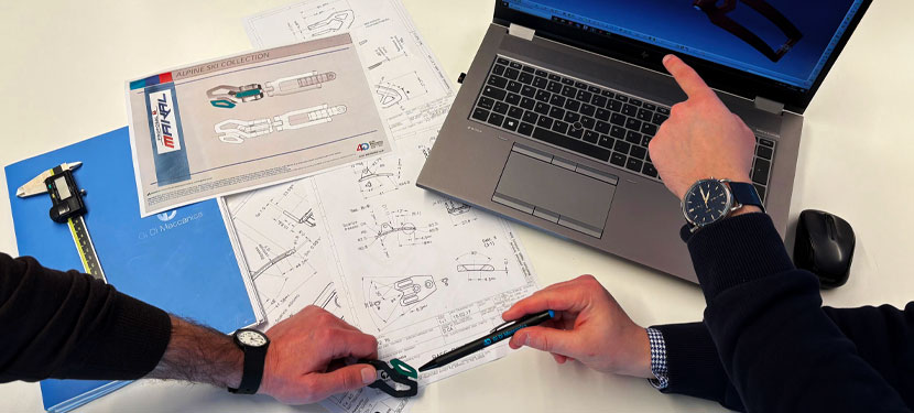 Two colleagues reviewing technical drawings and prototypes together.
